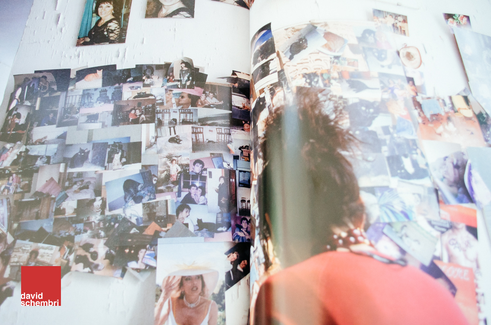 A photo of a printed photo of a woman looking at lots of photos